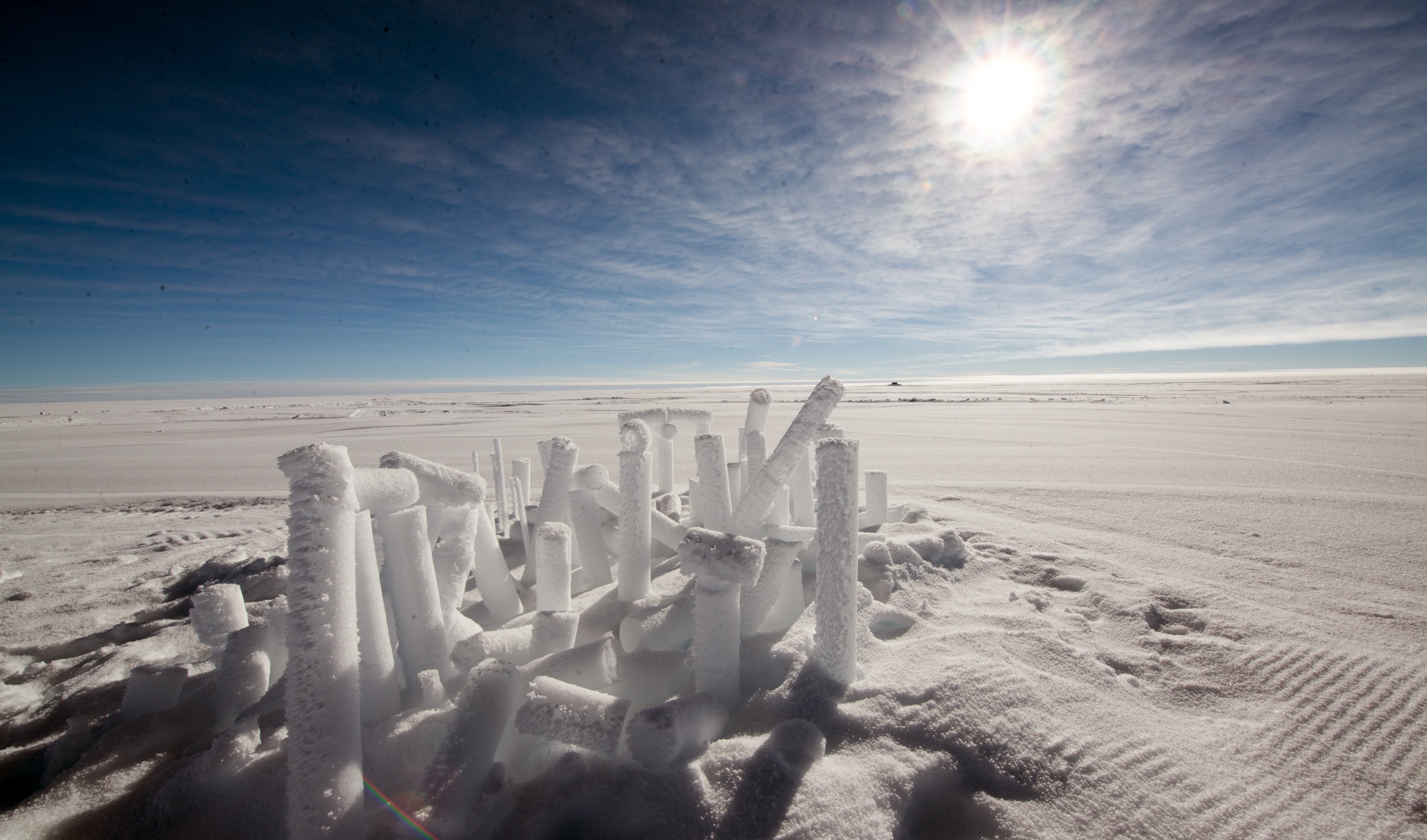 Discarded ice cores in the snow with sun shining down. 