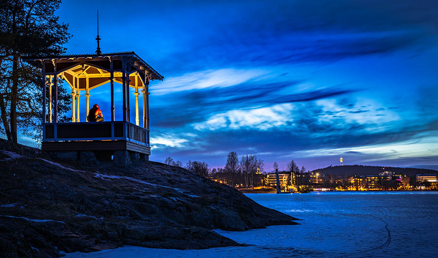 Finnish Lakeland, a man takes a moment of respite in a gazebo