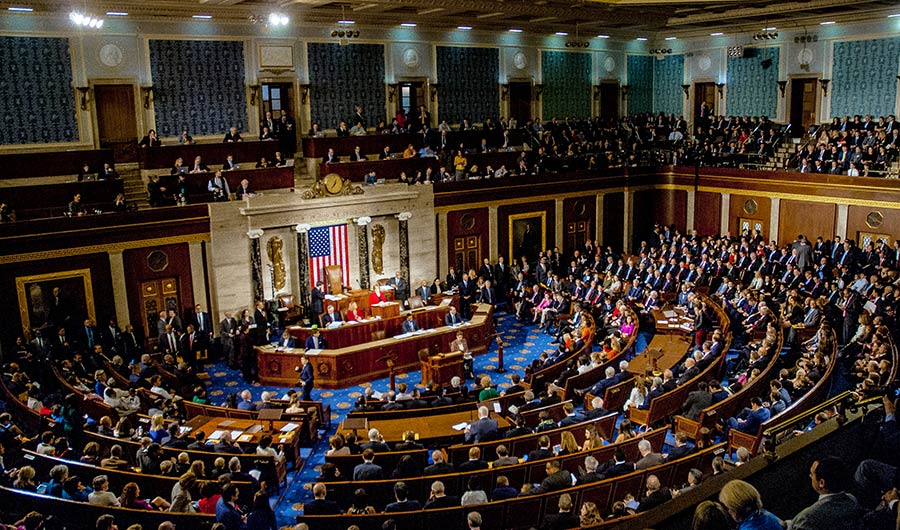An image of people collected on the floor of the House of Representatives. 