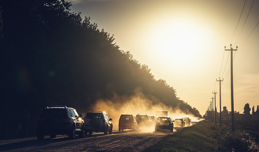 cars kicking up dust on a road